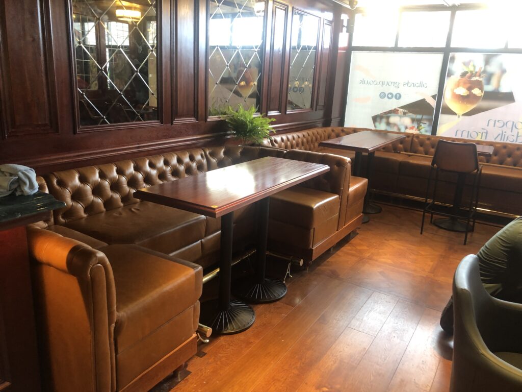 Tan buttoned booth seating across the timber-panelled café bar interior.
