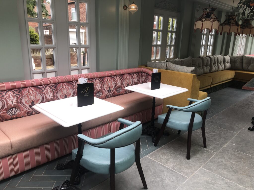 Pink and mustard banquette seating in the bright dining area at Allards Monkseaton.